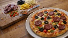 Ev usulü karışık pizza tarifi: yumuşak hamur, çıtır kenarlarla